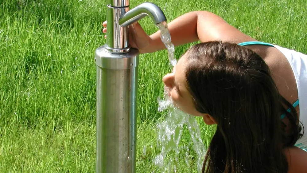 Frau an der Trinksäule im Kneipp Erlebnisdorf Niederdorf