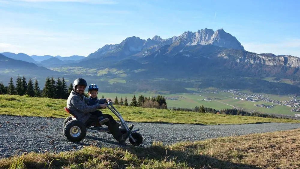 Vater mit Kind auf dem Mountaincart in St. Johann in Tirol