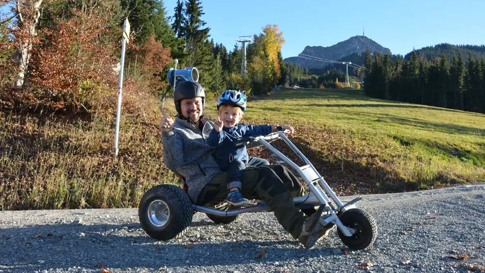 Vater mit Kind auf einem Cart in St. Johann in Tirol