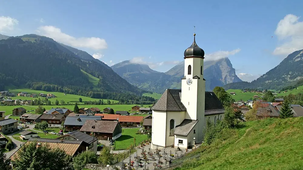 Die Pfarrkirche St. Philippus und Jakobus in Schoppernau mit Kanisfluh im Hintergrund