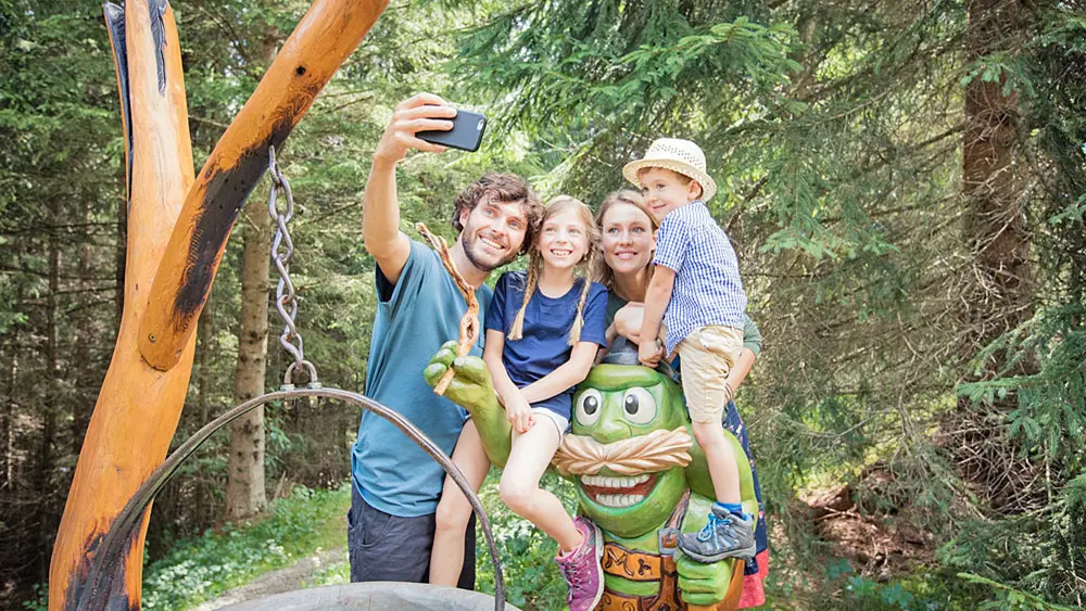 Familie beim Selfie mit Kobold Moosle in Moosles Zauberwald bei Lermoos