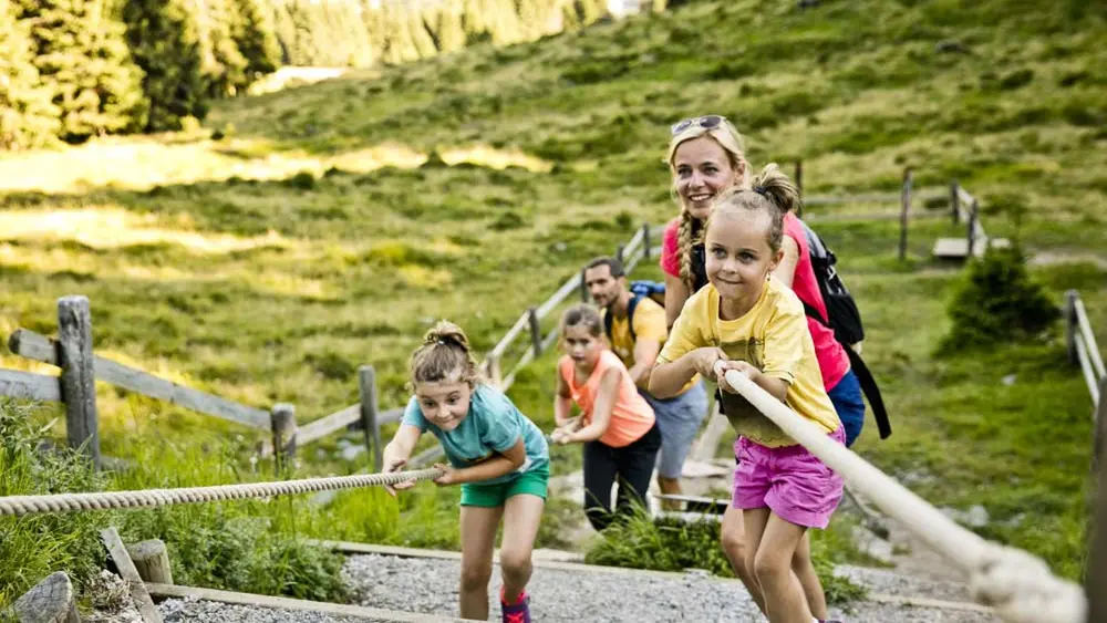 Familie an einer Spielstation auf dem Montelino Erlebnisweg