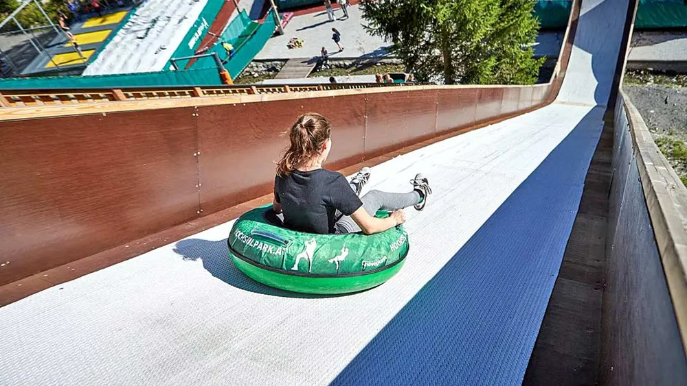 Mädchen auf der großen Rutsche im Jump & Slide Hinterglemm