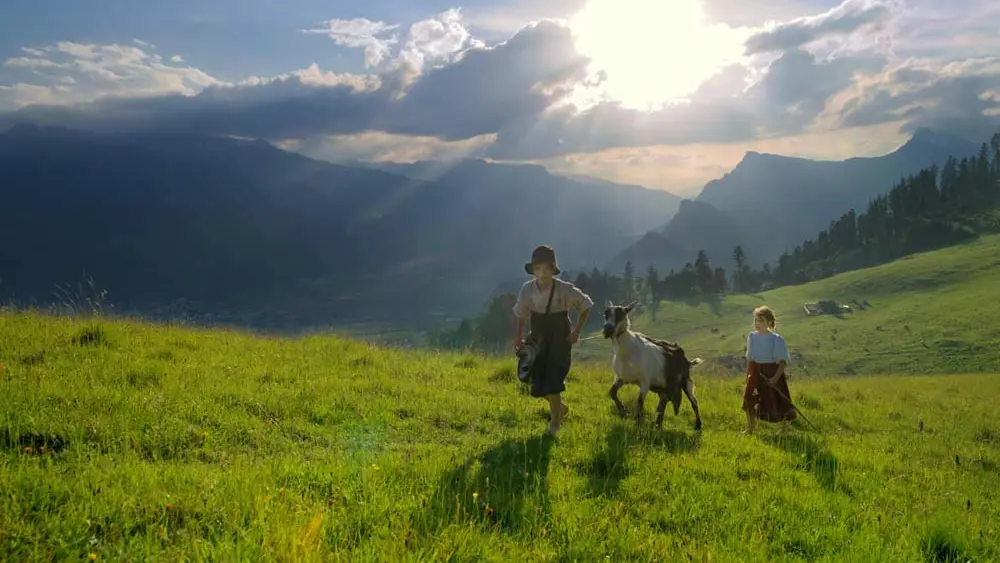 Heidi und Peter mit einer Ziege auf dem Heidipfad in den Bergen