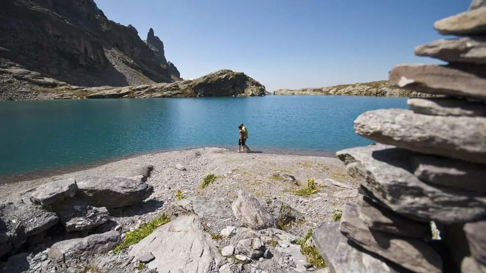Wanderer an einem See der Fünf-Seen-Wanderung bei Pizol