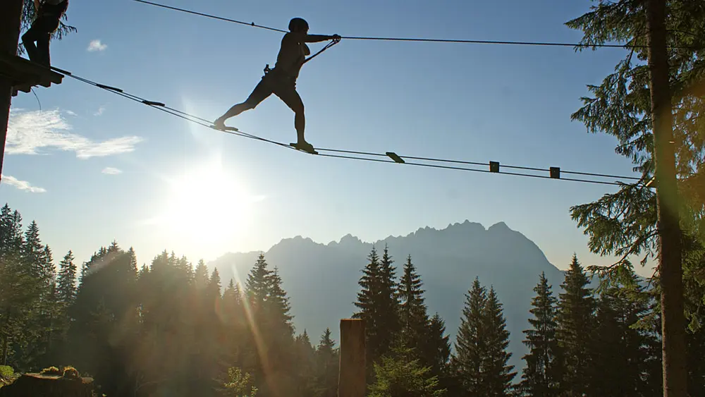 Kletterer auf einer Seilbrücke im Kletterwald Hornpark in St. Johann in Tirol