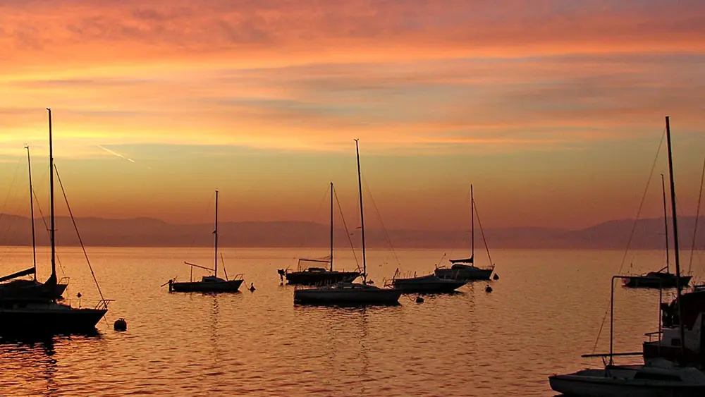 Segelschiffe bei Sonnenaufgang auf dem Lago Maggiore