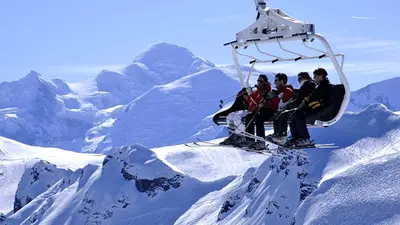 Wintersportler im Sessellift von Flaine mit Blick auf den Mont Blanc