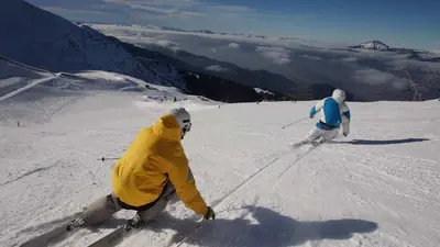 Skifahrer bei der Abfahrt im Skigebiet Les Sept Laux