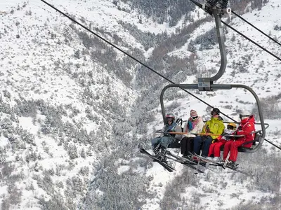 Vier Skifahrer in einem Sessellift in Serre Chevalier © OT / Mir Photos