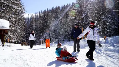 Familie auf dem Weg zum Rodeln