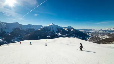Skifahrer auf der Piste mit Bergpanorama