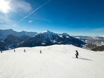 Skifahrer auf der Piste mit Bergpanorama © Gilles Baron