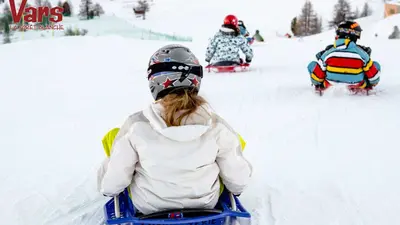 Kinder beim Rodeln von hinten