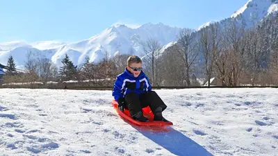 Kind beim Rodeln in Mont-Dore
