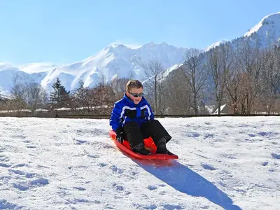 Kind beim Rodeln in Mont-Dore © OT Massif du Sancy