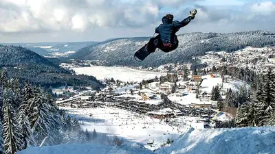 Snowboarder beim Sprung hoch über Gérardmer
