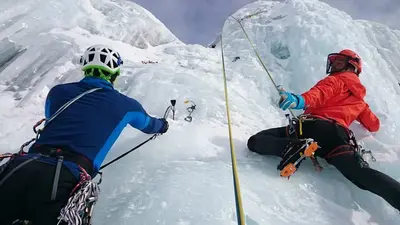 Zwei Eiskletterer an einem Wasserfall