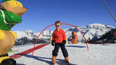 Kind auf Ski im Kinderland