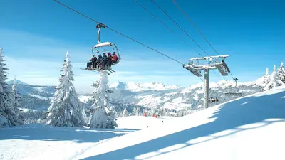 Sessellift mit Skifahrern über dem Skigebiet