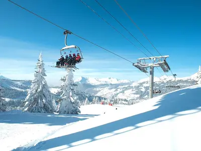Sessellift mit Skifahrern über dem Skigebiet © Les Gets