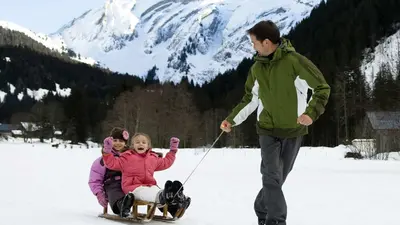 Vater mit Kinder beim Rodeln
