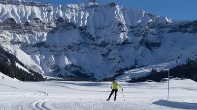 Langläufer auf einer Loipe vor den Bergen