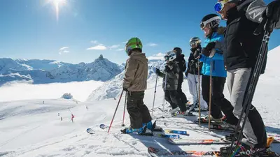 Skifahrer auf der Piste mit Bergpanorama