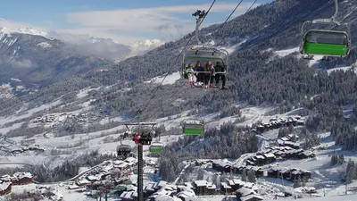 Sessellift mit Skifahrern über dem Skigebiet