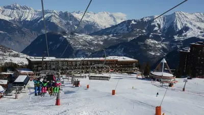 Sessellift mit Skifahrern über dem Skigebiet