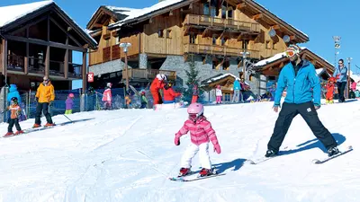 Kind mit Skilehrer beim Skifahren in Sainte-Foy-Tarentaise