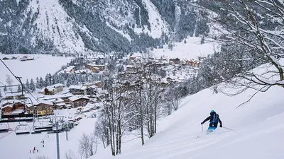 Blick auf den Ort Pralognan-la-Vanoise und einen Skifahrer bei der Abfahrt