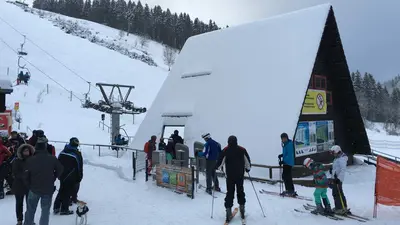 Skifahrer an der Hütte der Talstation