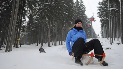 Frau auf einem Schlitten auf einer Rodelbahn am Wurmberg