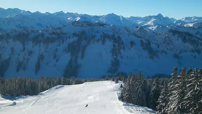 Blick auf einen Skifahrer auf einer breiten leeren Piste in Grasgehren