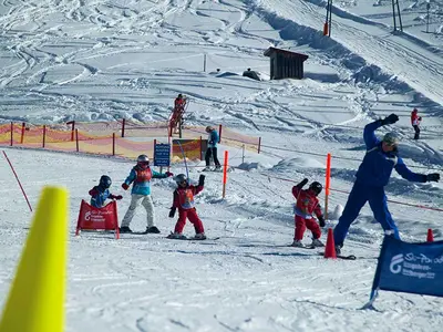 Skilehrer mit Kindernbeim Slalomfahren in der Skischule Grasgehren © Skiparadies Grasgehren