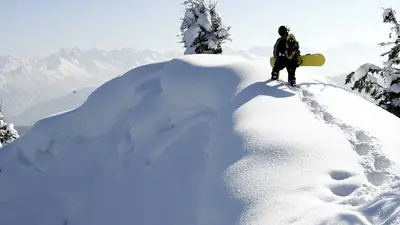 Snowboarder steht im Tiefschnee am Horngrat in Bolsterlang