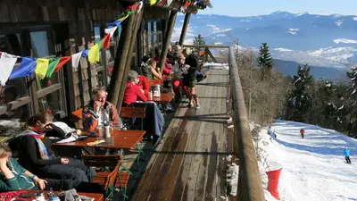 Sonnenterrasse des Berghauses mit Blick auf die Piste