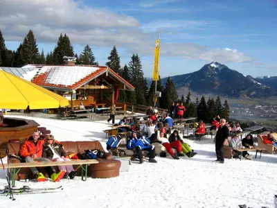 Menschen beim Sonnenbaden auf Sofas vor der Hochbichlhütte am Ofterschwanger Horn © Bergbahnen Ofterschwang-Gunzesried GmbH