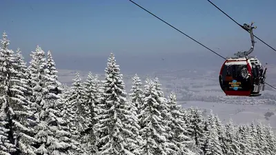 Blick auf Gondel über verschneiten Baumwipfeln in Nesselwang