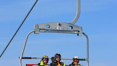 Drei Skifahrer im Sessellift Nesselwang