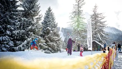 Blick auf Lehrer und Kinder beim Snowboardkurs in Nesselwang