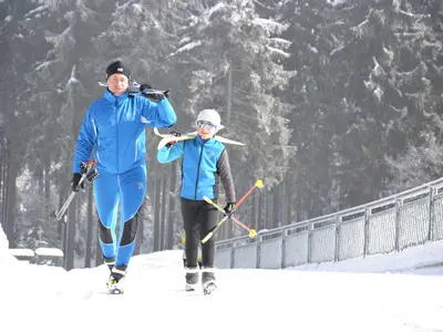Vater und Sohn mit Ski auf den Schultern in Klingenthal © Tourist-Info Klingenthal