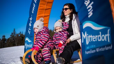 Familie rodelt im Skigebiet Mitterdorf