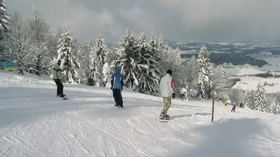 Snowboarder auf der Piste im Snowpark Oberfrauenwald mit Blick ins Tal