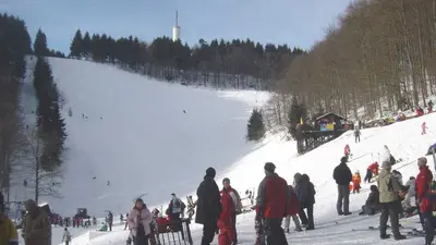 Piste mit Skifahrer im Vordergrund