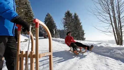 Frau auf einem Rodel