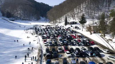 Blick auf den Parkplatz mit Autos im Skigebiet Bläsiberg