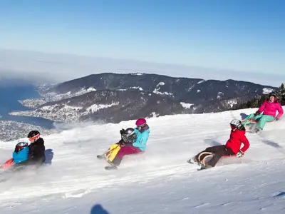 Rodler auf der Rodelbahn - Tegernsee im Hintergrund © Wallbergbahn / Eugen Gebhardt