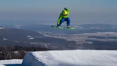 Snowboarder über einem Obstacle im Snowpark